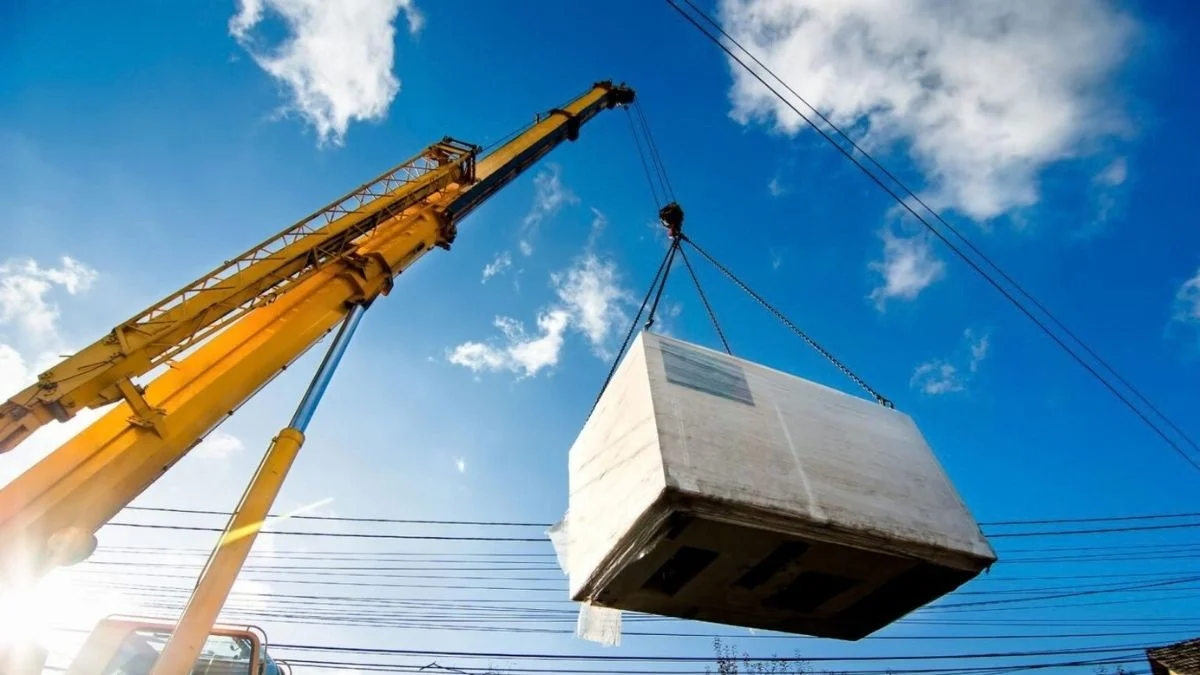Carga sendo elevada por guindaste e cabos de aço